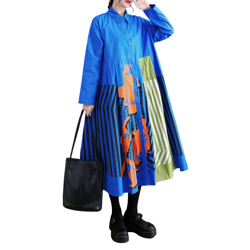 Model wearing a blue button-front shirt dress with striped skirt and orange and yellow-green panels, front view.