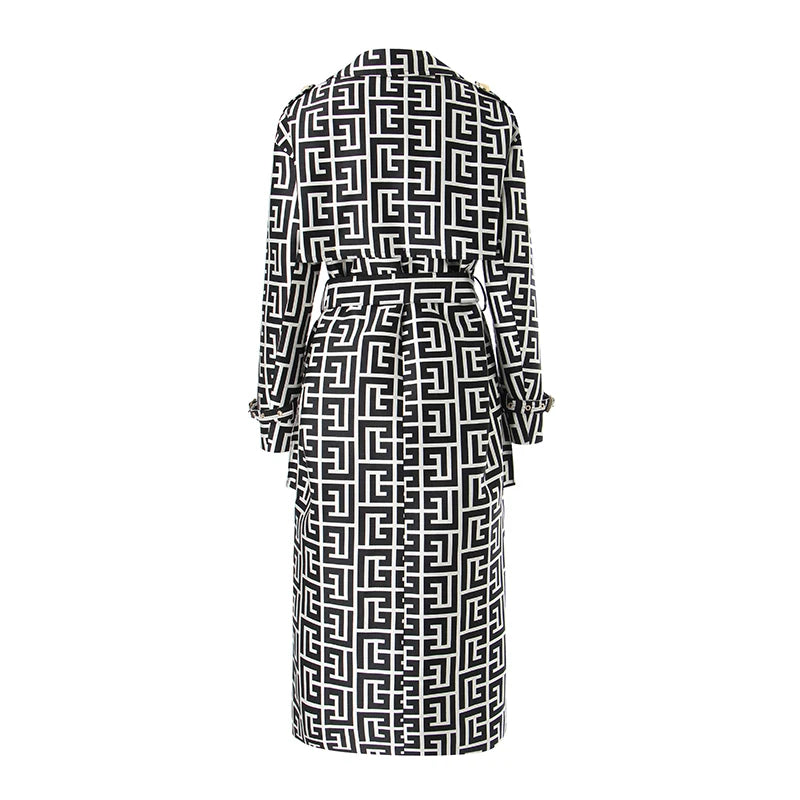 Back view of a black and white geometric trench coat with a matching waist tie and cuff straps.