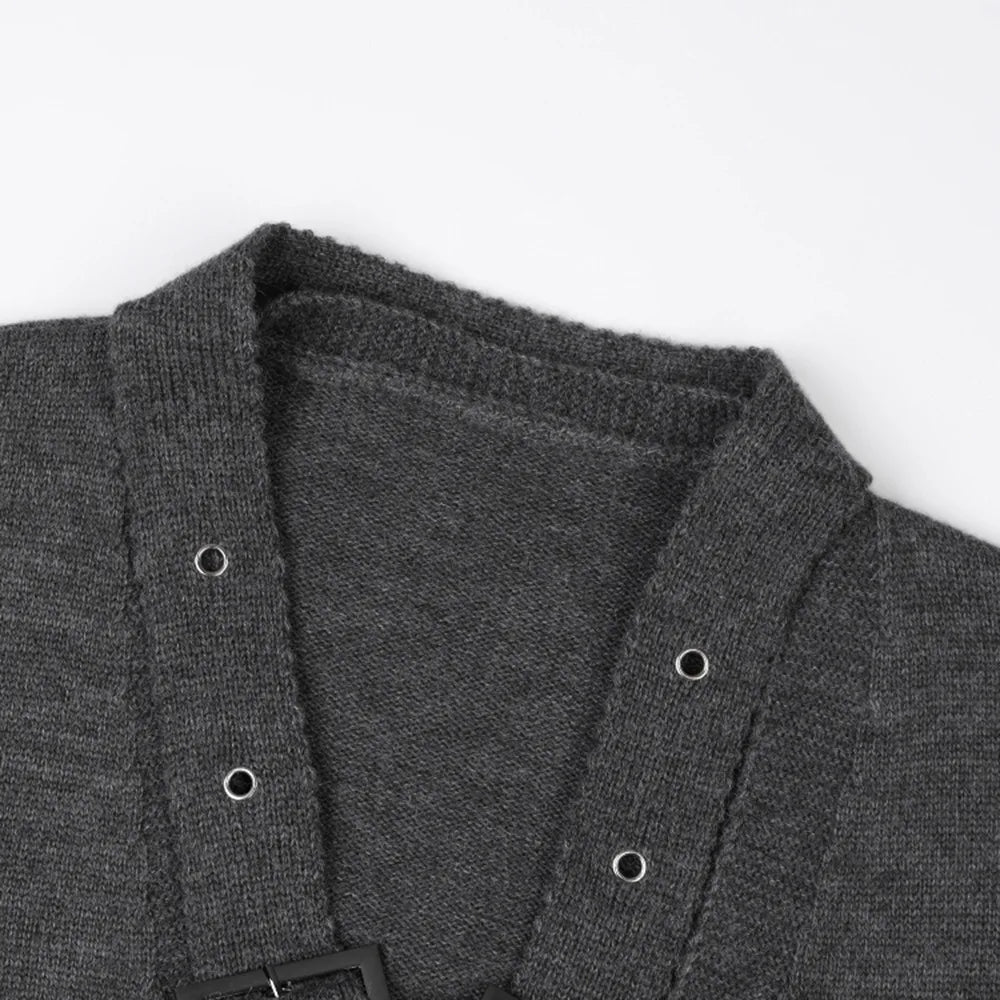 Close-up of the gray sweater's V-neck, knit texture, and metal eyelets on crossed buckle straps.