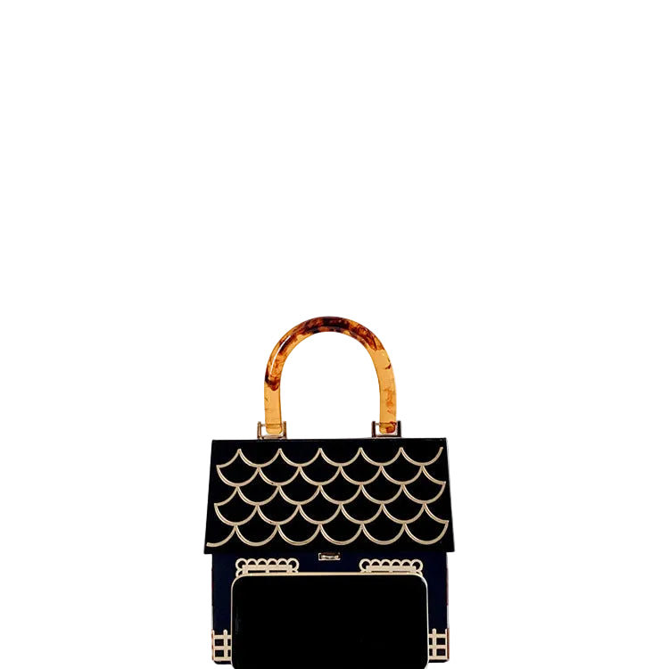 Black house-shaped handbag with gold details and an amber patterned handle, shown behind a black phone.