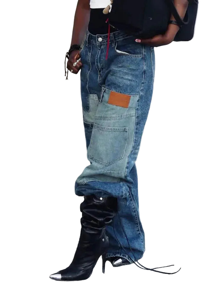 Angled view of blue wide-leg jeans showing oversized patchwork pockets and a brown patch.