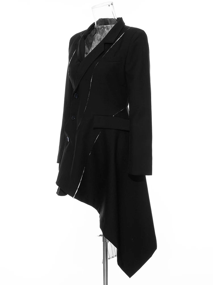 Angled view of a black asymmetric blazer showing the long pointed hem and striped lining panel.