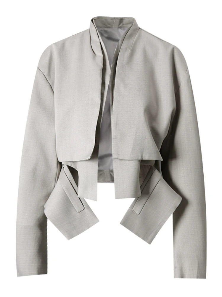 Light gray cropped jacket with a stand collar, layered front, angular hanging panels, and dark piping, front view.