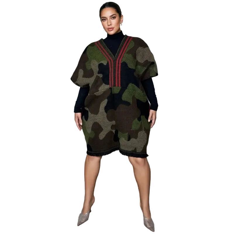 Model wearing a camouflage V-neck tunic with red stripes, layered over a black turtleneck.