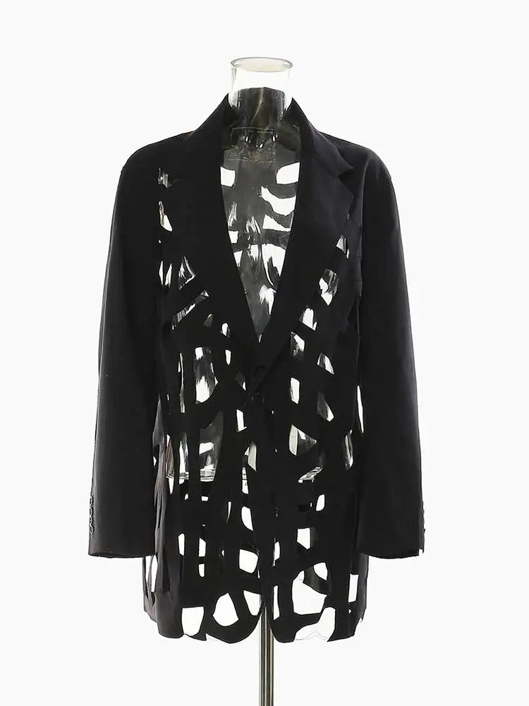 Black blazer with notched lapels, geometric cutouts, and solid long sleeves on a clear mannequin, front view.