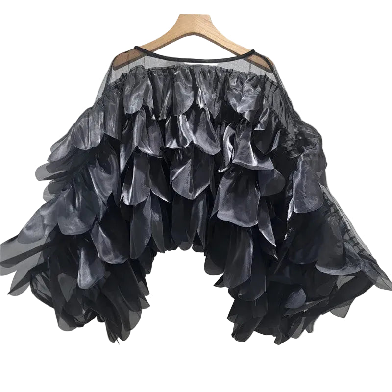 Black sheer blouse with layered petal details and wide bell sleeves, hanging front view.