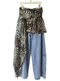 Angled view of light blue jeans with a leopard-print overlay and side pockets.