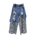 Distressed blue jeans with gray camouflage lower panels, cargo pockets, and side waist buckles, front view.