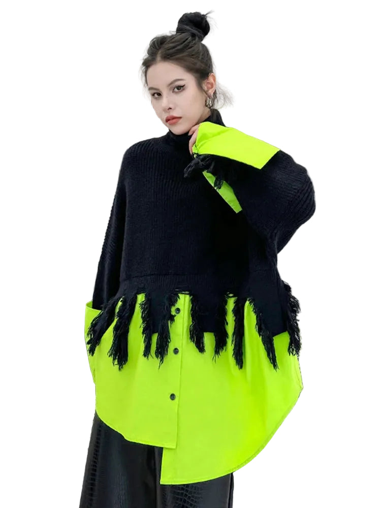 Person wearing a black and neon green outfit with fringe details in an indoor setting.