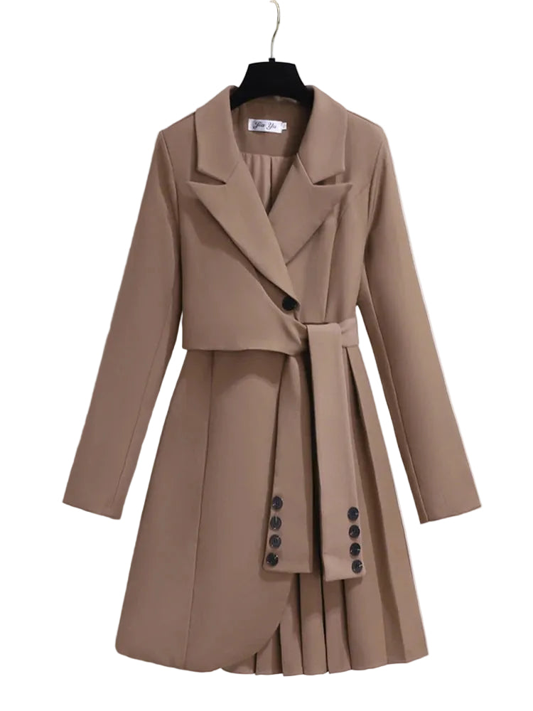 Taupe blazer-style dress with notched lapels, sleeve-like waist ties, and an asymmetric pleated skirt, front view.