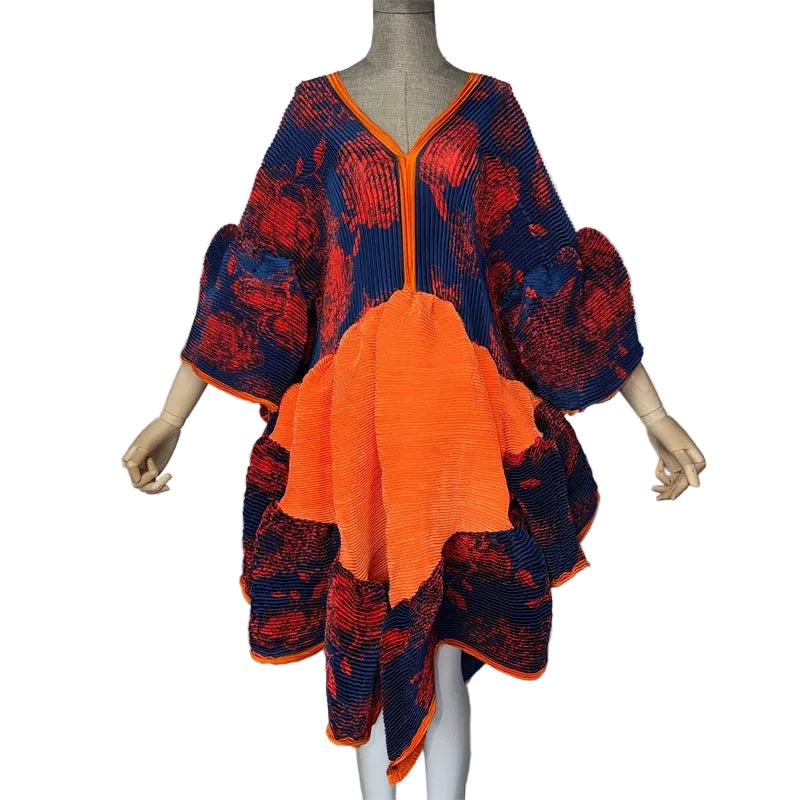 Navy and red floral pleated dress with an orange front panel, puffed sleeves, and irregular hem on a mannequin.