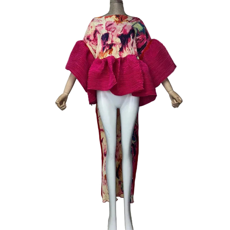 Pink floral pleated top with flared sleeves, a pink peplum, and a long printed back panel on a mannequin.