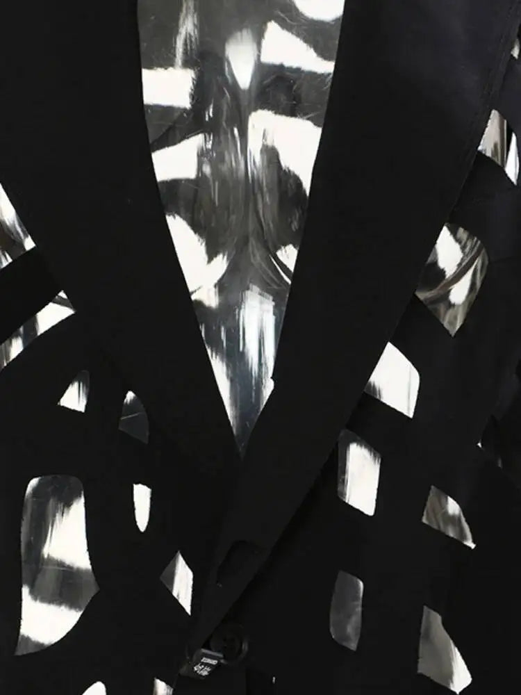 Close-up of the black cutout blazer's notched lapels and geometric openings.