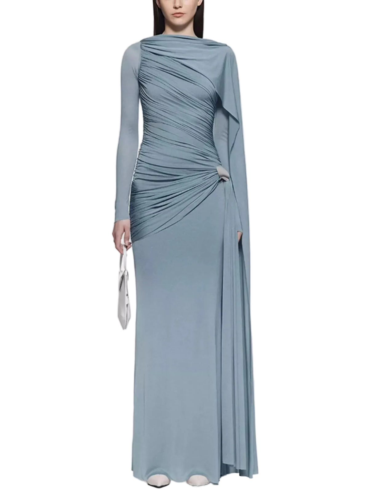 Model wearing a dusty blue long-sleeve ruched gown with a draped shoulder panel and silver hip accent, front view.