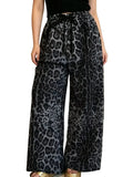 Model wearing gray and black leopard-print wide-leg pants with a drawstring waist and sparkling dots, front view.
