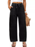 Model wearing black wide-leg jeans with a drawstring elastic waist and curved leg seams, front view.