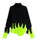 Neon Noir Tassel Sweater with a black turtleneck knit, fringed hem, and neon green shirt-style cuffs and lower panel, shown against a white background.