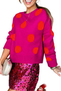 Model wearing a bright pink crewneck sweater with oversized orange polka dots, front view.