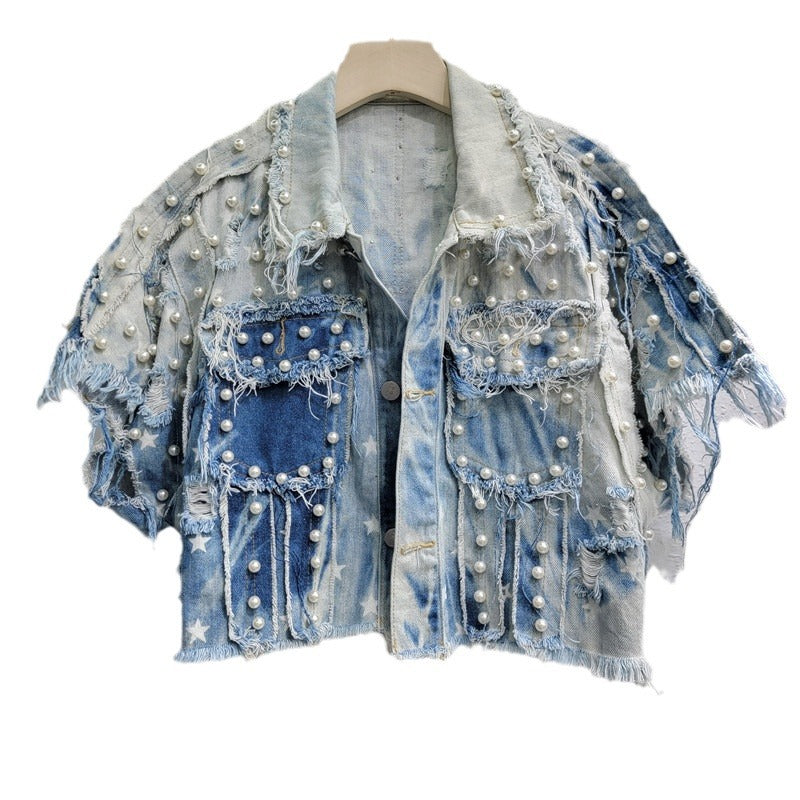 Cropped blue distressed denim top with white stars, pearl-like studs, frayed seams, and flap pockets.