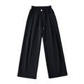 Black wide-leg pants with an elastic waistband, drawstring, silver button, and slanted pockets, front view.