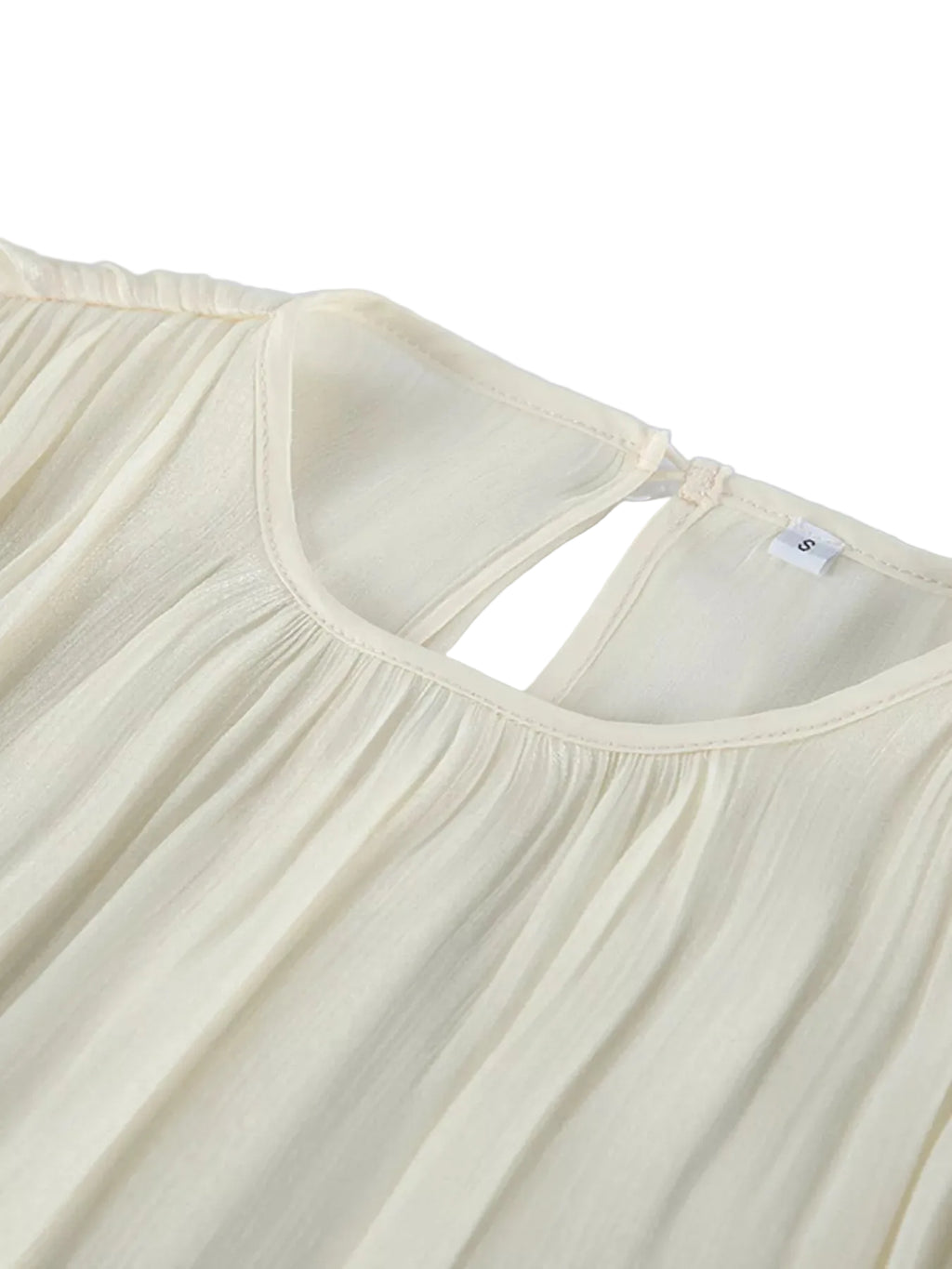 Close-up of the ivory blouse's gathered round neckline and back keyhole opening.