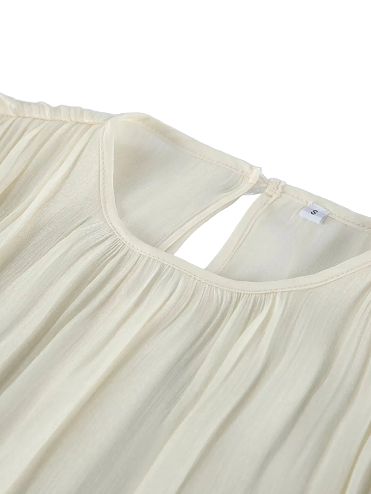 Close-up of the ivory blouse's gathered round neckline and back keyhole opening.