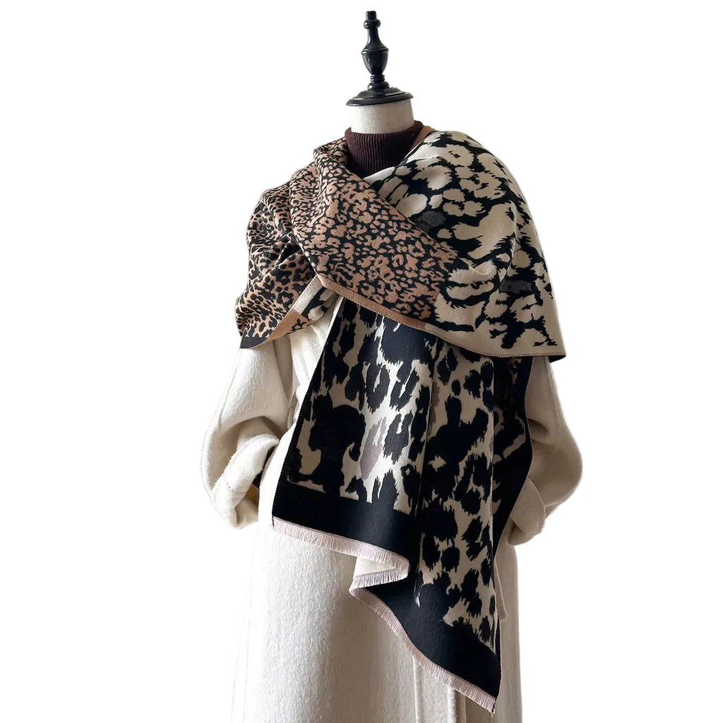 Beige and black mixed-scale leopard-print scarf with short fringe wrapped across a mannequin's shoulders.