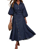 Model wearing a dark blue denim wrap-front shirt dress with balloon sleeves, buttons, and a waist tie.