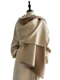 Beige and taupe two-tone scarf with short fringe draped around the shoulders of a mannequin.