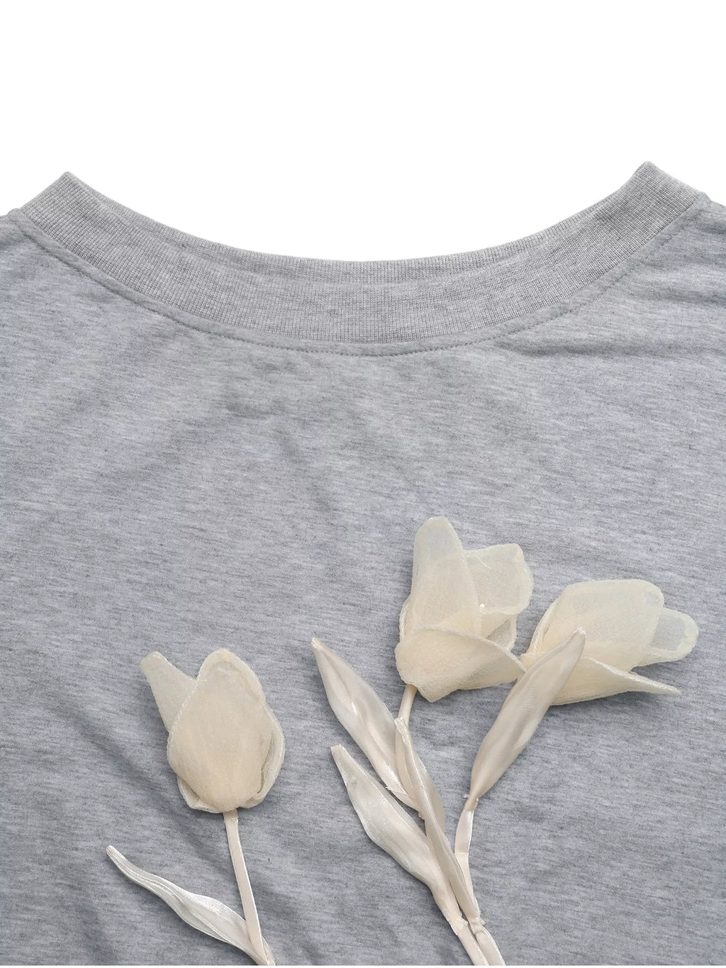 Close-up of the gray sweatshirt's ribbed neckline and cream tulip-shaped floral appliques.